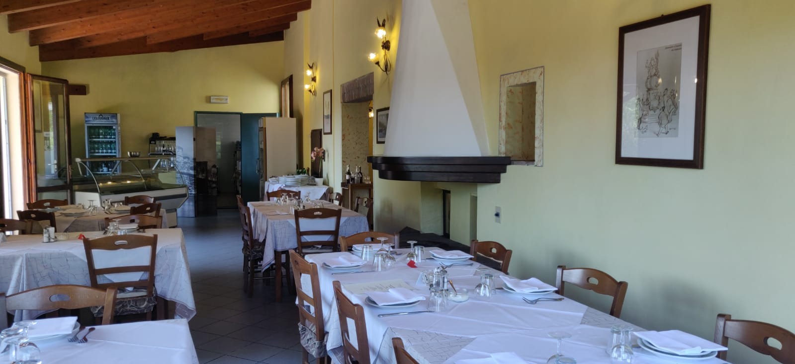 Sala interna con camino e tavoli apparecchiati, trattoria a Modena, Castelnuovo Rangone